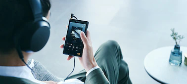 圖中人物用連接有線耳機的 WM1AM2 Walkman 聆聽音樂